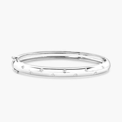 An 18ct white gold drop set diamond bangle with several round brilliant cut diamonds, displayed against a white background.