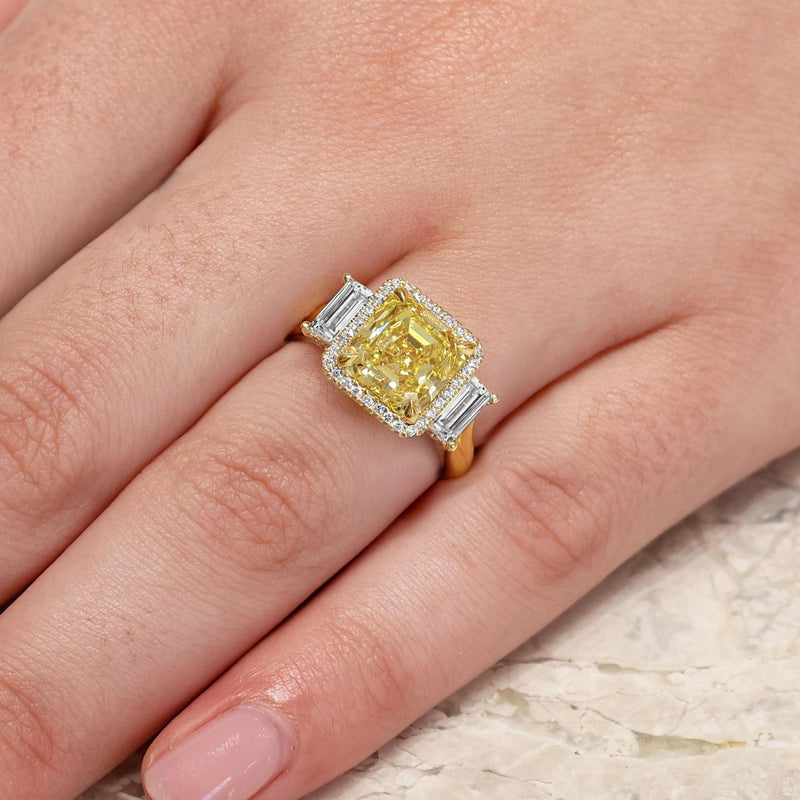 18ct yellow gold Fancy Vivid Yellow asscher cut diamond ring with baguette and round brilliant cut diamonds on the finger 