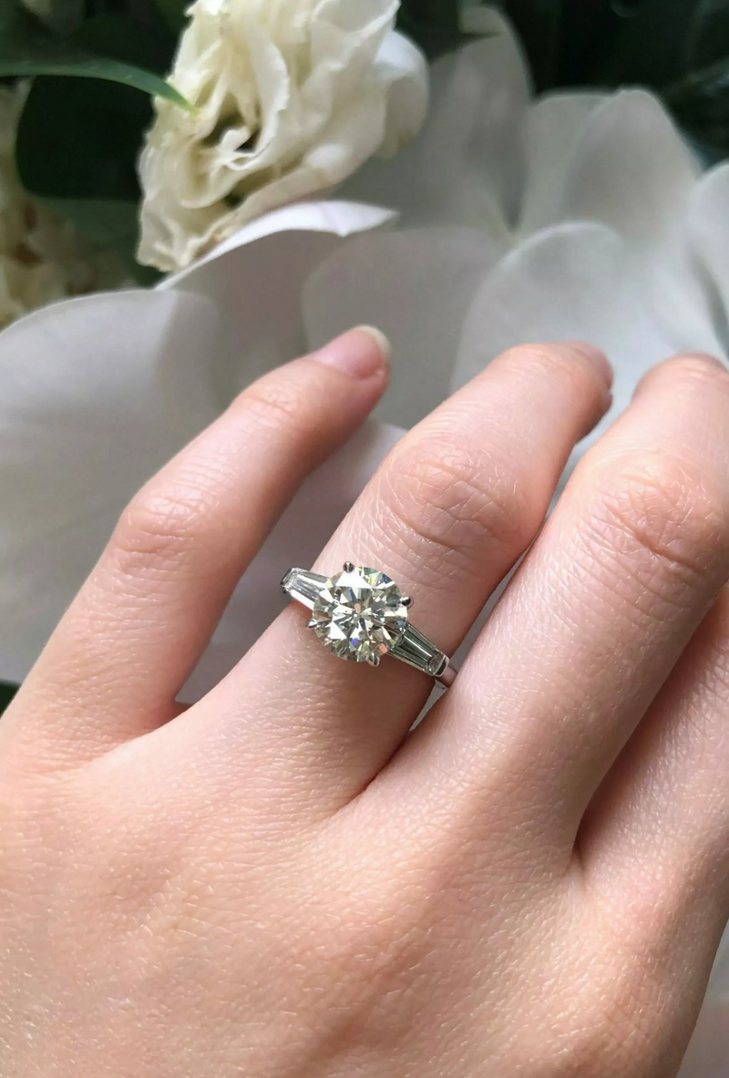 18ct white gold round brilliant and tapered baguette trilogy ring on finger