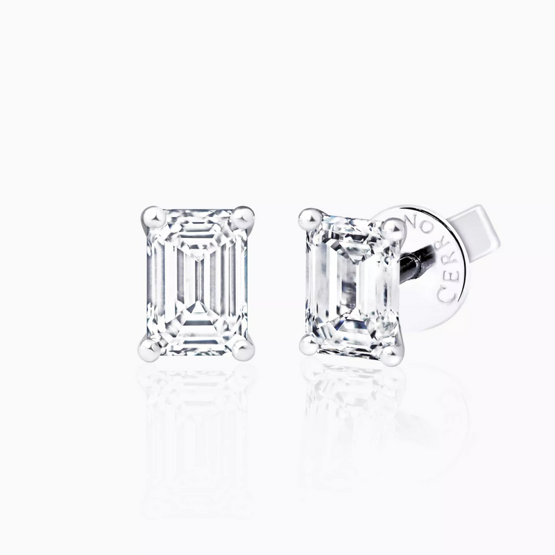 A pair of 18ct white gold emerald cut diamond stud earrings with a four claw setting.