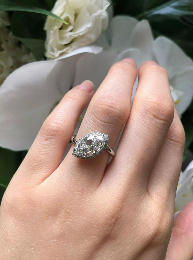 18ct white gold marquise and round brililant cut halo ring on finger