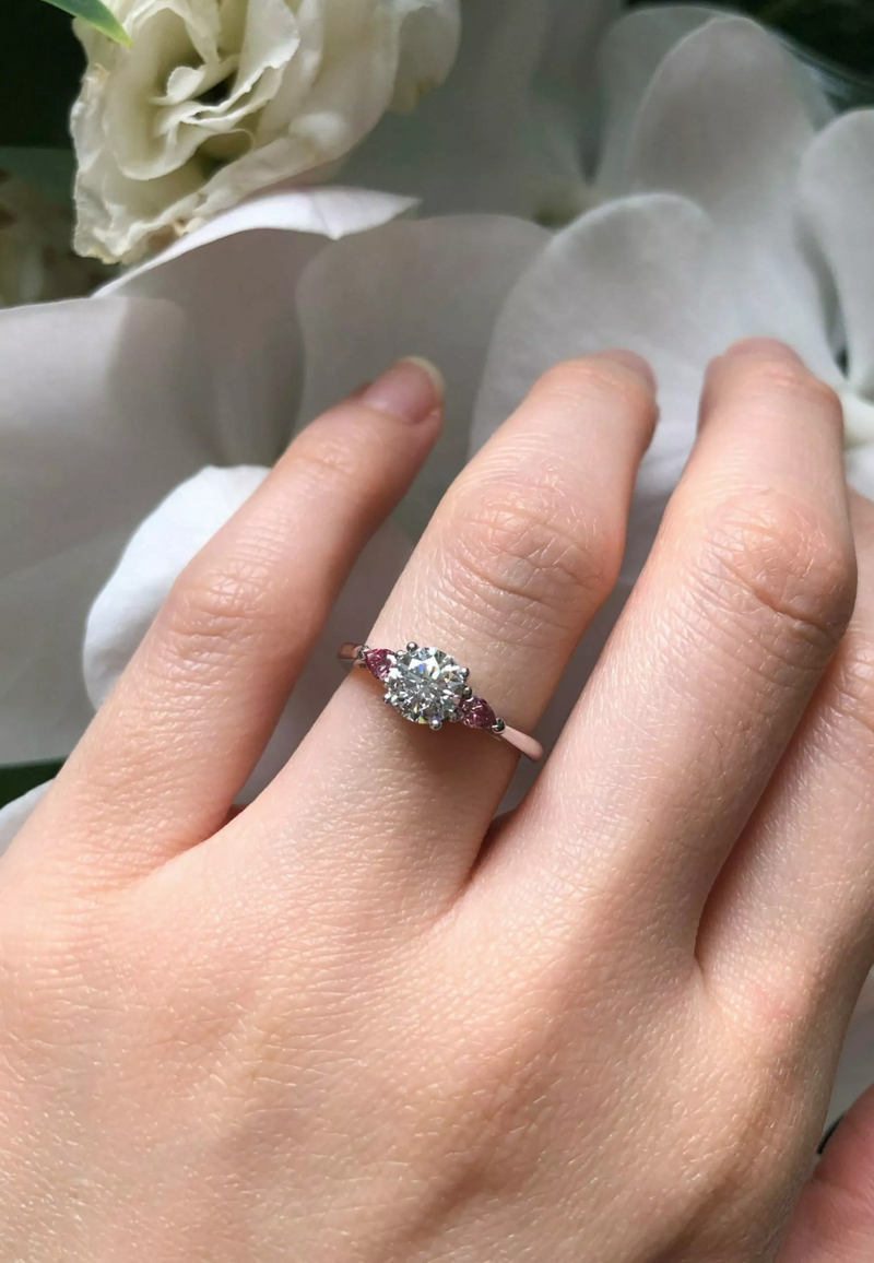 18ct white gold round brilliant cut and Argyle pink diamond trilogy ring on finger