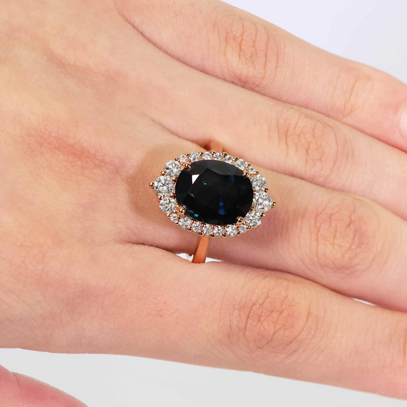 18ct rose gold oval Australian sapphire and round brilliant cut diamond ring on finger