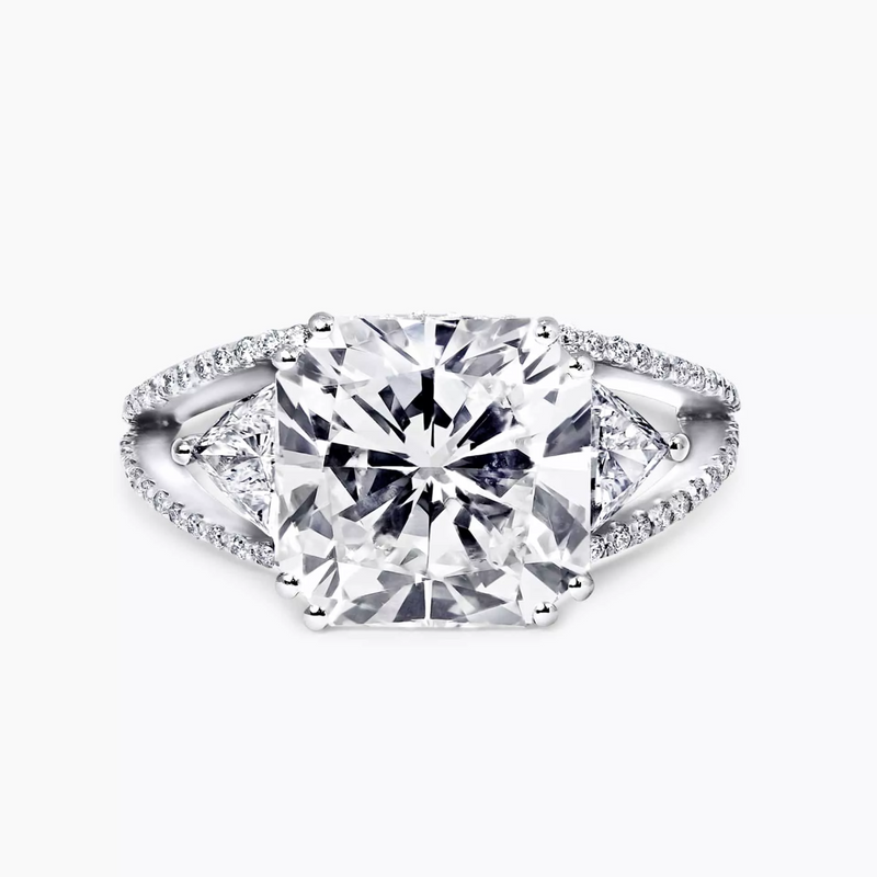 18ct white gold radiant and trilliant cut trilogy ring with round brilliant cut shaped halo