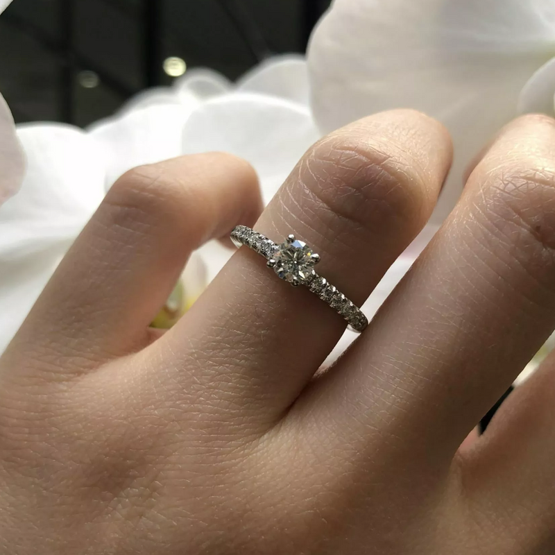 Platinum round brilliant cut diamond ring on finger