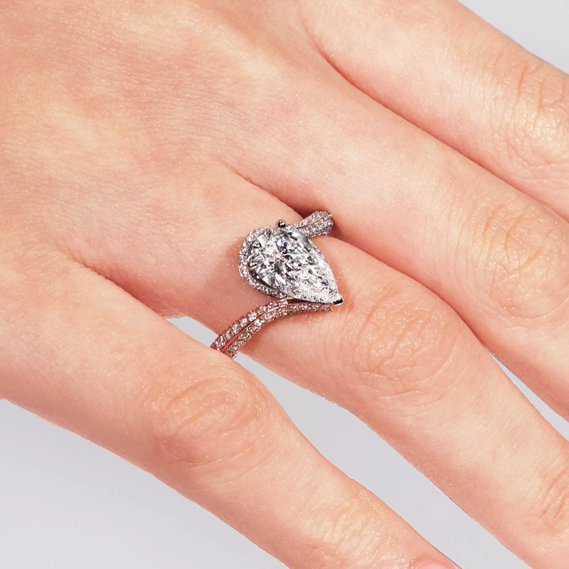 18ct white and rose gold pear and round brilliant cut diamond knife edge ring on finger