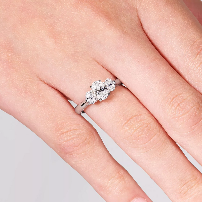 18ct white gold oval cut diamond three stone ring on finger