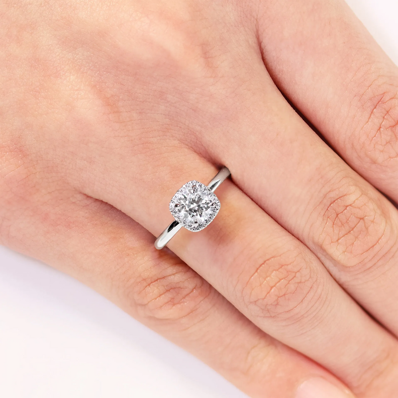 Platinum round brilliant cut diamond halo ring on finger