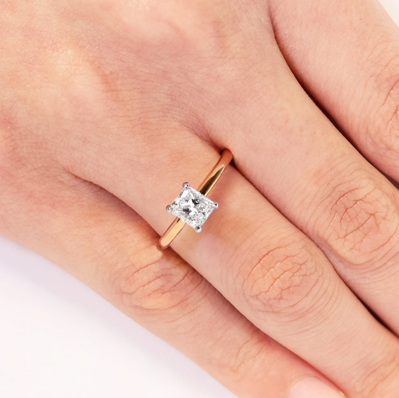 18ct rose and white gold radiant cut diamond hidden halo ring on finger