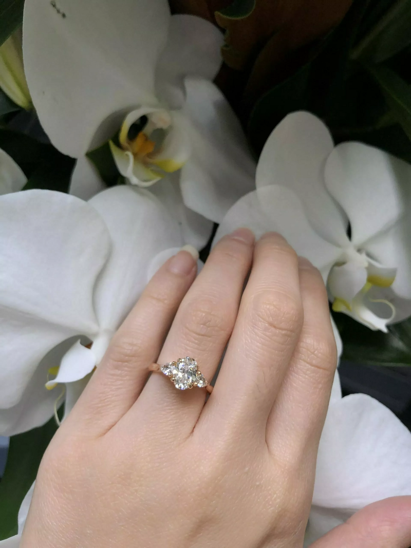 18ct rose gold oval and pear trilogy diamond ring on finger