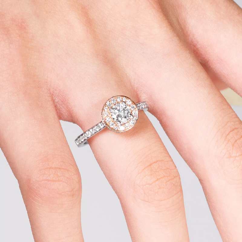 18ct white and rose gold round brilliant cut diamond halo ring on finger