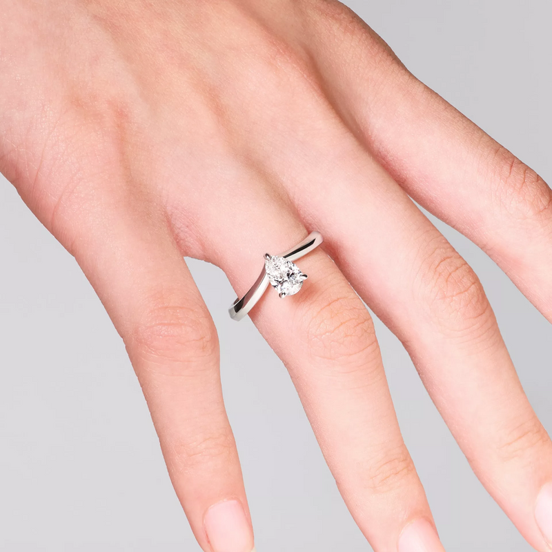 Platinum pear shape diamond solitaire ring on finger