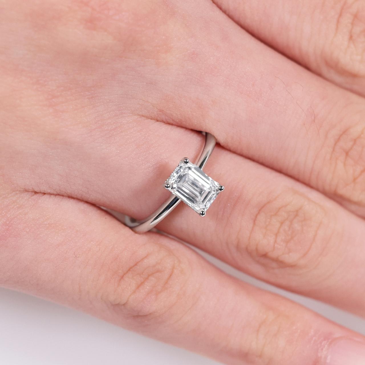 18ct white gold 1.20ct emerald cut diamond engagement ring on finger