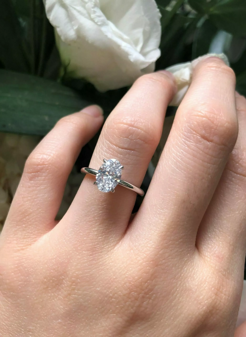 18ct white gold oval diamond hidden halo ring on finger