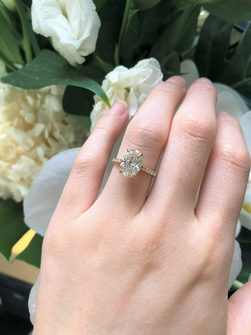 18ct rose gold oval brilliant cut diamond four claw upswept ring on finger