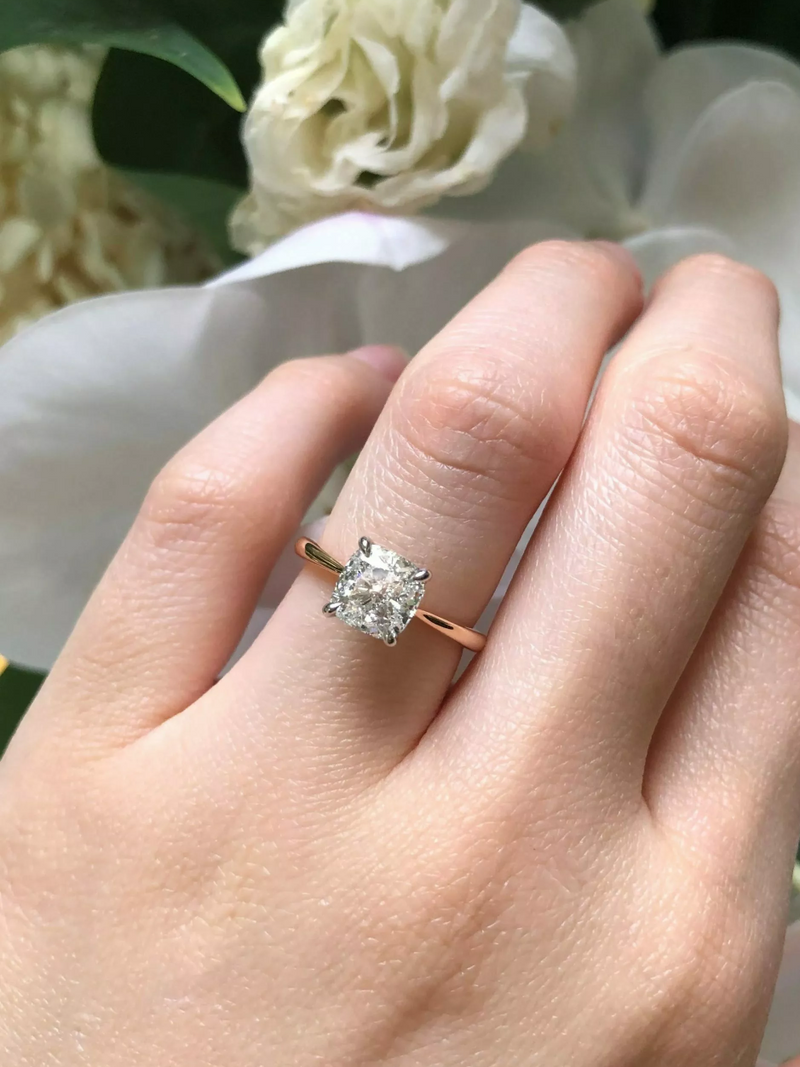 18ct rose and white gold cushion cut diamond four claw upswept tapered ring on finger