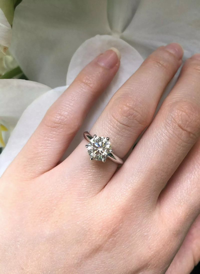 18ct white gold round brilliant cut diamond six claw knife edge solitaire diamond ring on finger