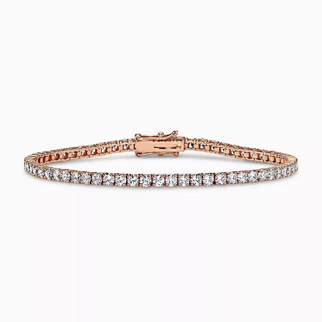 An 18ct rose gold diamond tennis bracelet with round brilliant cut diamonds in a four claw setting.