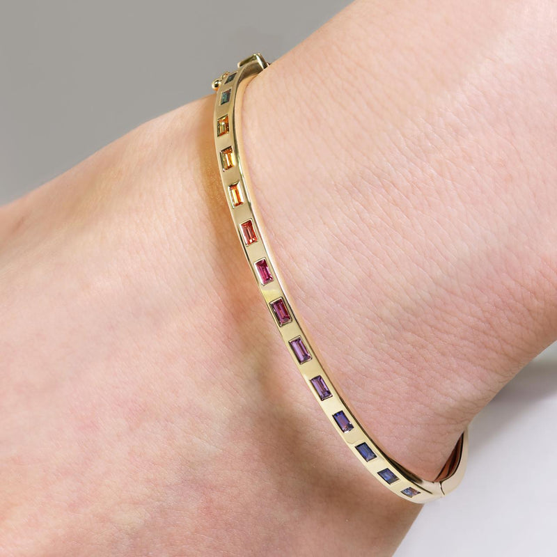 18ct yellow gold multi colour sapphire drop set hinged bangle on the wrist