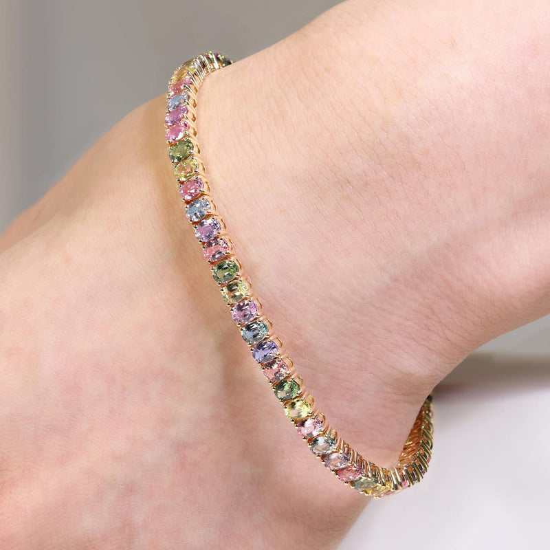 18ct yellow gold 11.29ct oval multi-colour sapphire four claw set bracelet on the wrist