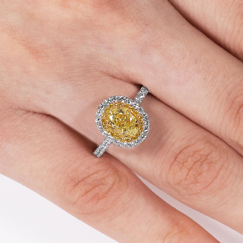 Platinum and 18ct yellow gold 1.04ct Fancy Intense Yellow oval and round diamond double halo ring on finger