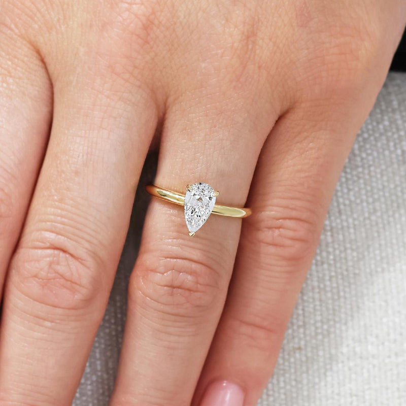 18ct yellow gold 1.09ct pear shaped diamond solitaire ring in a three claw setting on finger