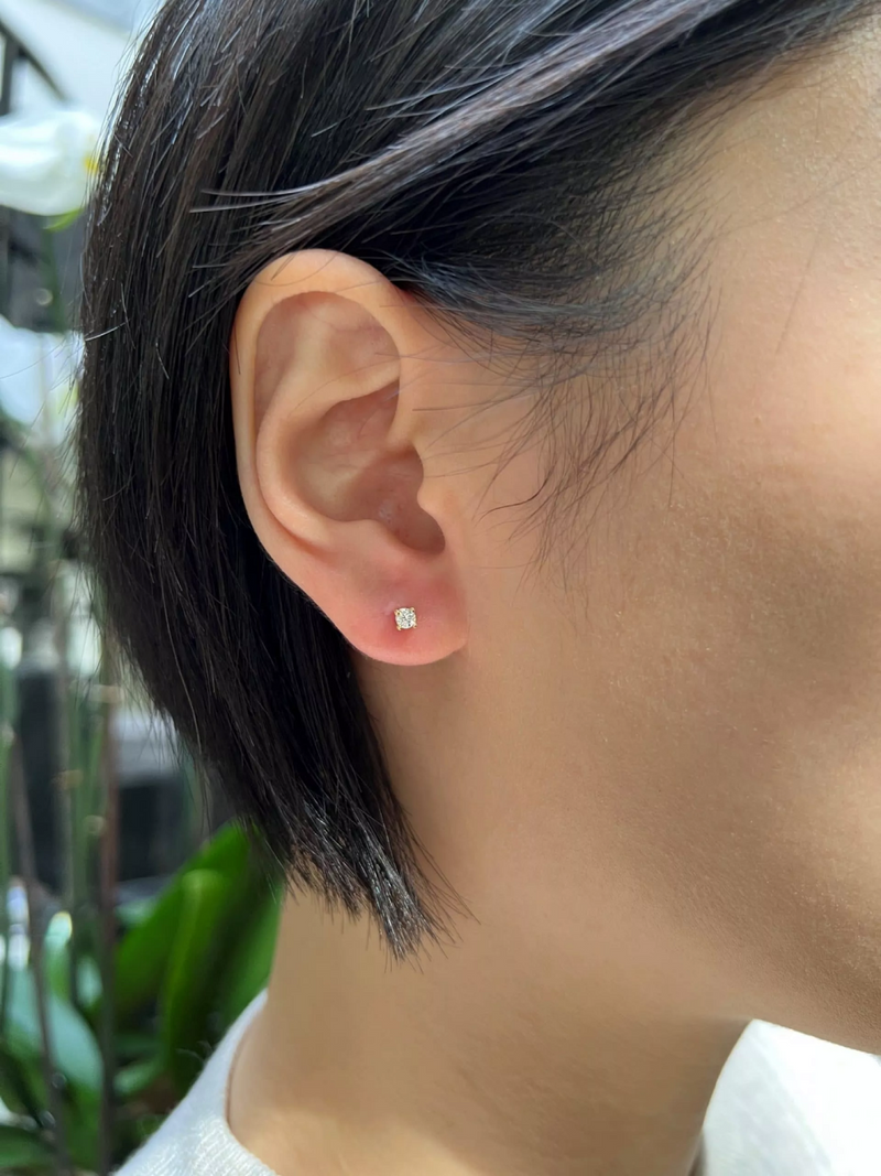 18ct yellow gold round brilliant cut diamond solitaire stud earrings in a four claw setting on the ear