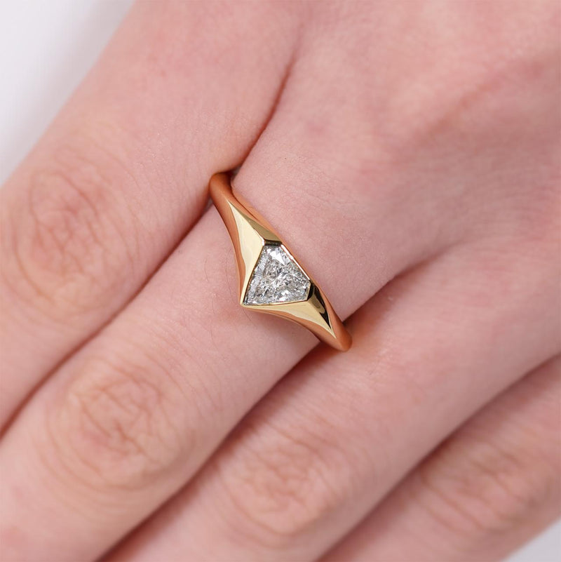 18ct yellow gold trilliant cut diamond ring in a bezel setting on the finger