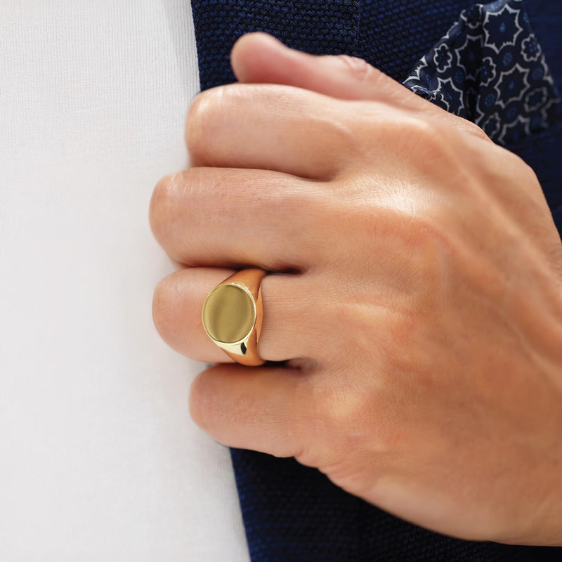 18ct yellow gold round signet ring on the finger