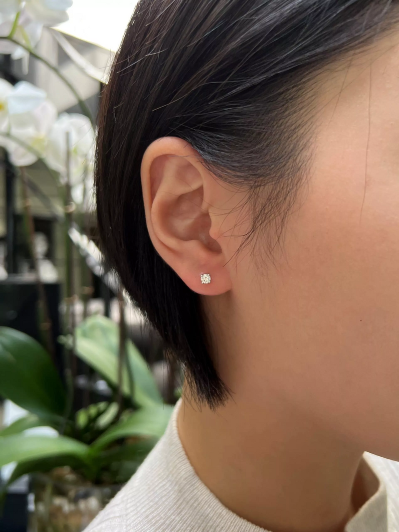 18ct yellow gold round brilliant cut diamond solitaire stud earrings in a four claw setting on the ear