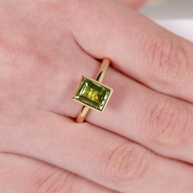 18ct yellow gold 1.90ct baguette peridot ring in a bezel setting on the finger