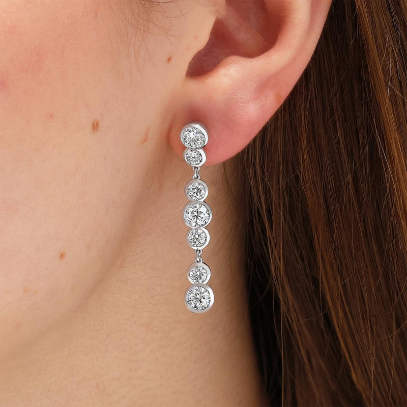 18ct white gold 4.83ct round diamond drop earrings in a bezel setting on ear