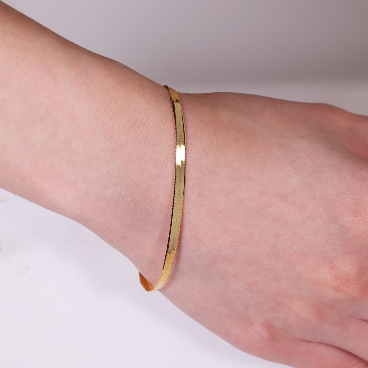 18ct yellow gold 19cm herringbone bracelet with parrot clasp on the wrist