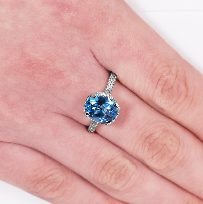 18ct white gold oval Swiss blue topaz and diamond ring on the finger