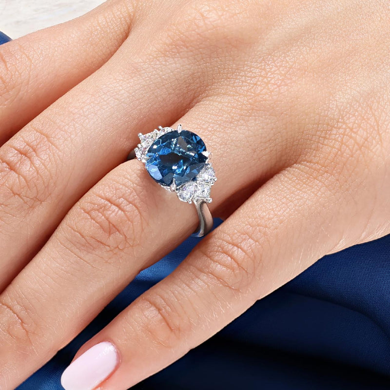 18ct white gold 6.09ct oval shape London blue topaz and diamond ring with pear, princess and round brilliant cut diamonds on the finger
