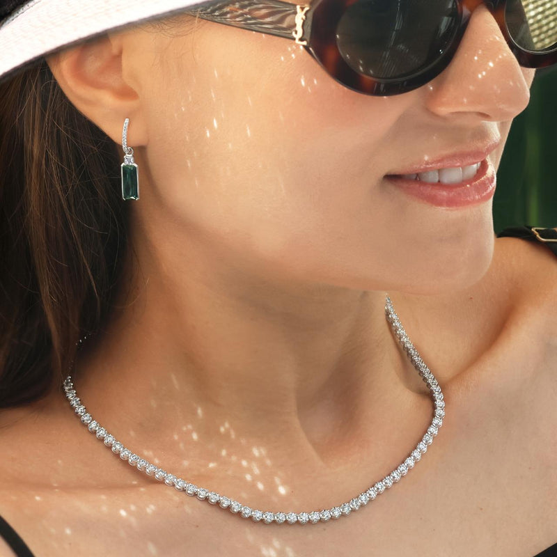 18ct white gold round brilliant cut diamond tennis necklace in a four claw crown setting displayed on the neck