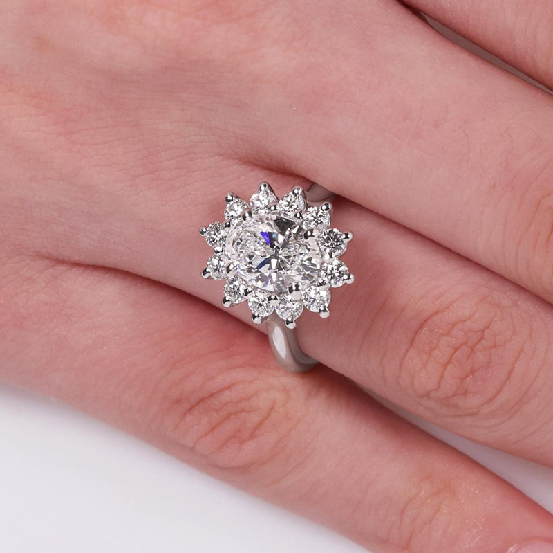 18ct white gold oval and round brilliant cut diamond halo ring on finger