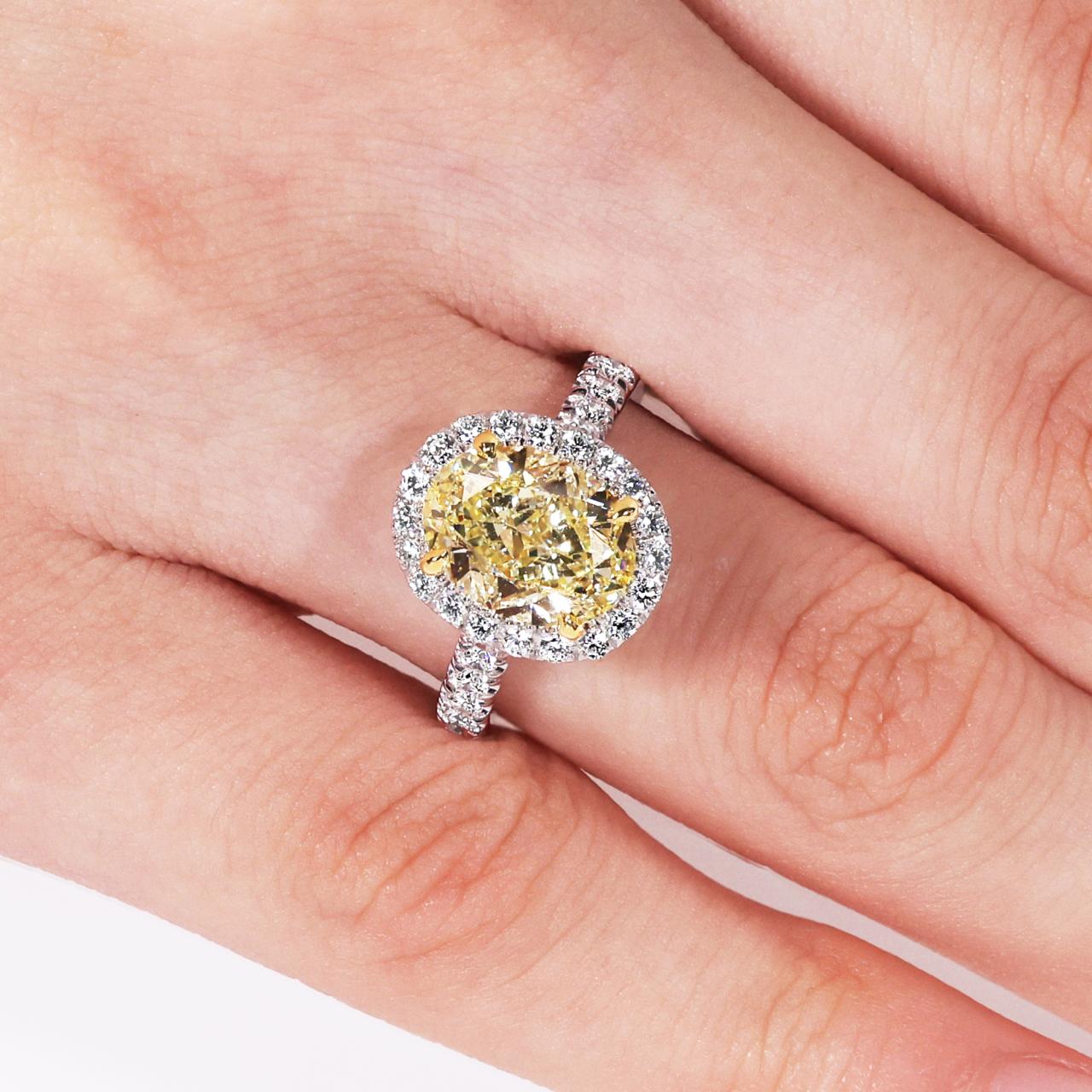 18ct white and yellow gold 3.50ct fancy yellow oval cut and white diamond halo ring