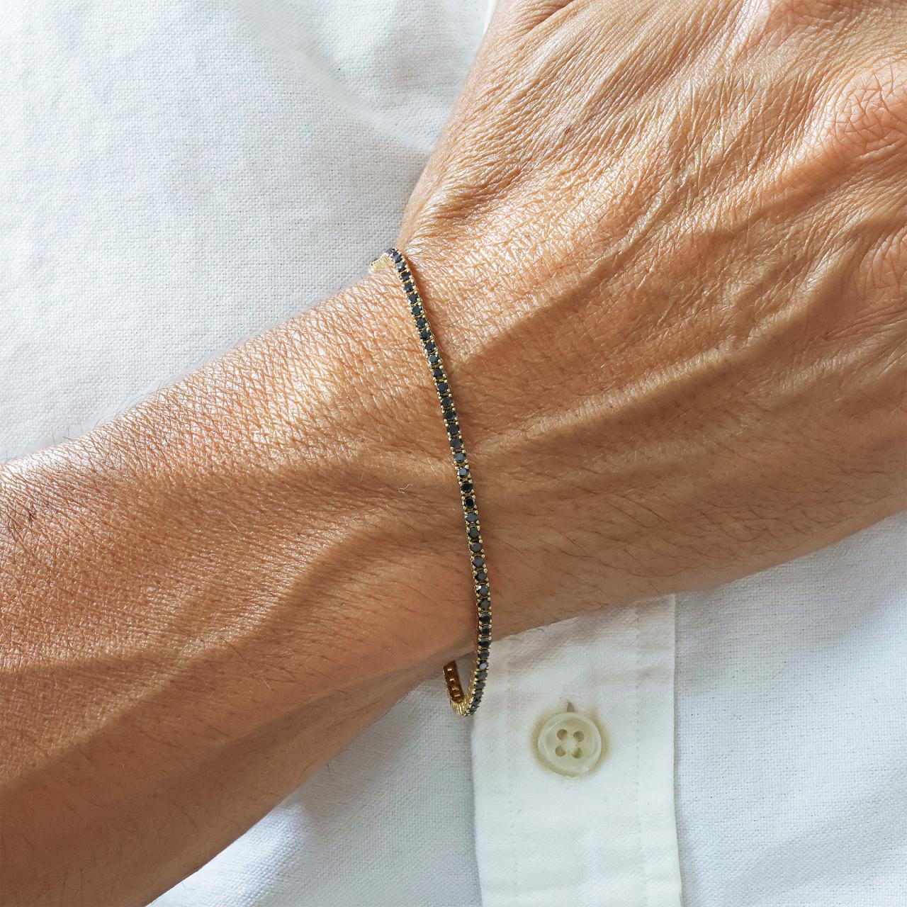 18ct yellow gold black round diamonds tennis bracelet in a four claw setting on wrist