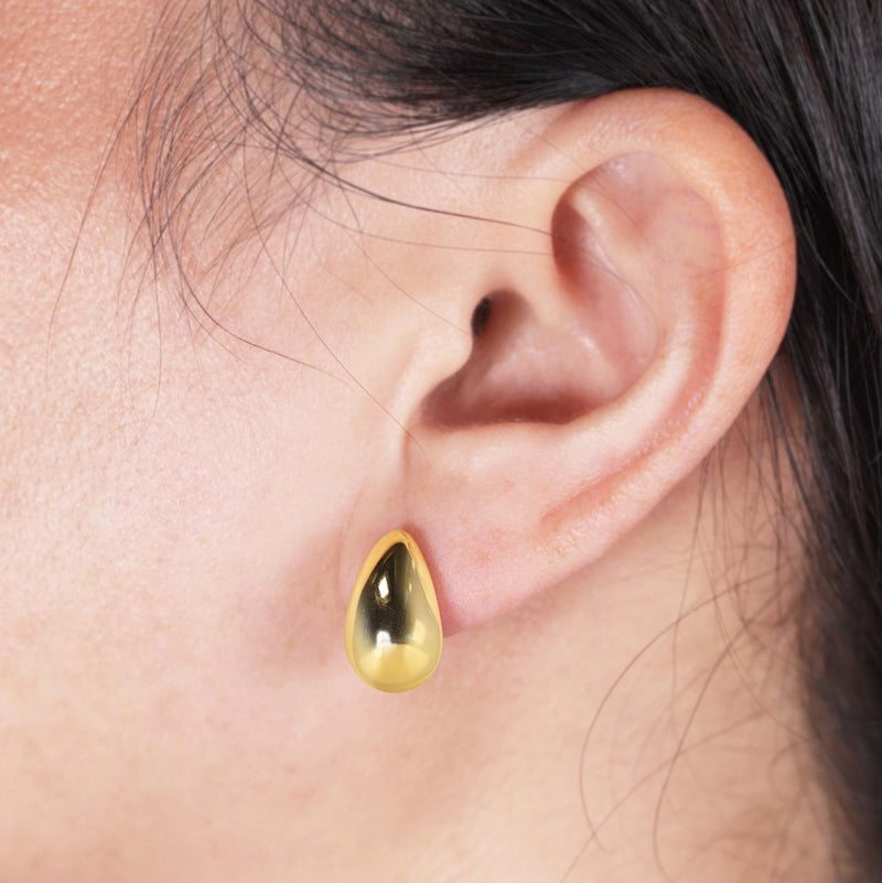 18ct yellow gold hollow tear drop stud earrings worn on the ear