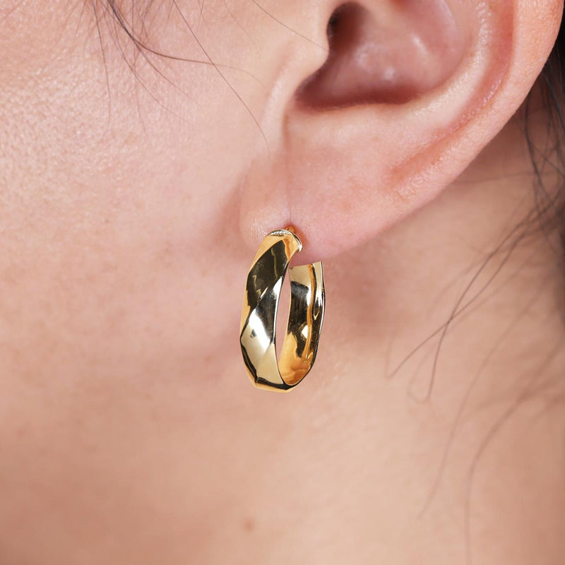 18ct yellow gold hollow faceted oval hoop earrings on the ear