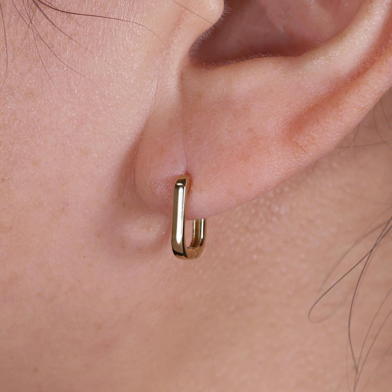 18ct yellow gold hollow oval huggies on the ear