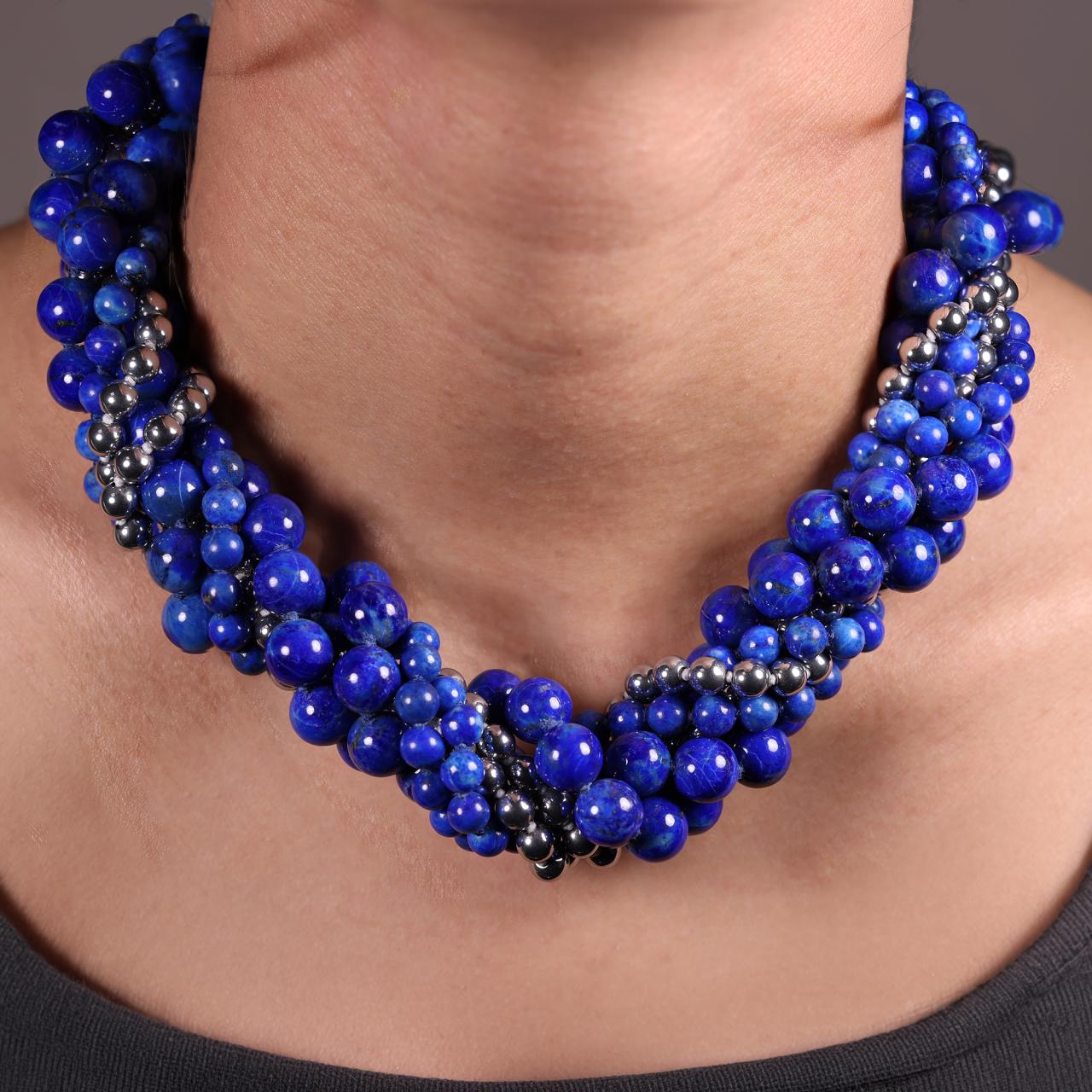 Blue lapis and silver plated hemitite beads bracelet ended with a silver magnetic clasp from the Carmela Cerrone Collection on the neck