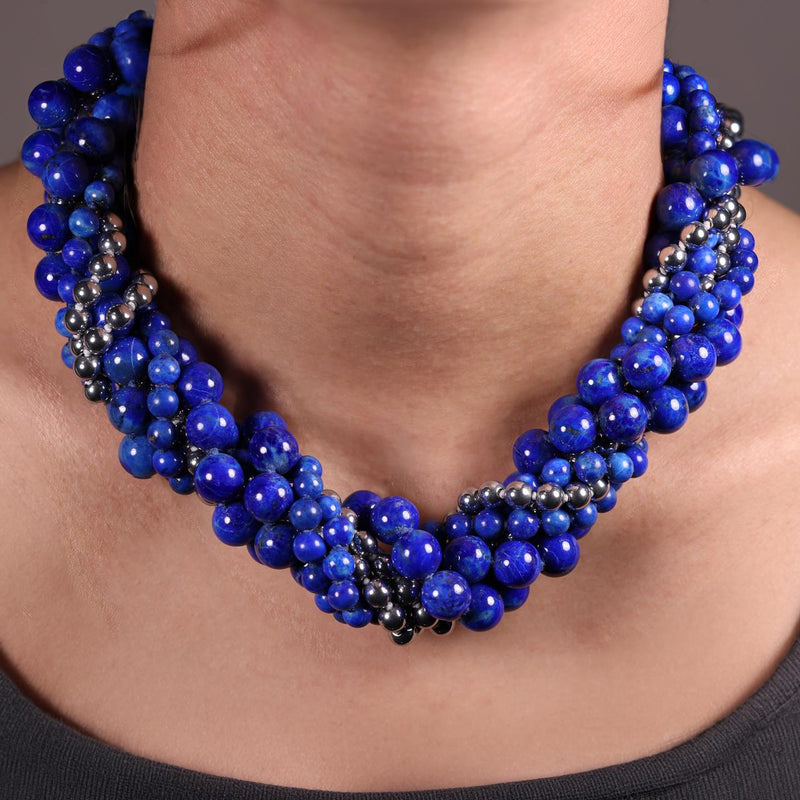 Blue lapis and silver plated hemitite beads bracelet ended with a silver magnetic clasp from the Carmela Cerrone Collection on the neck
