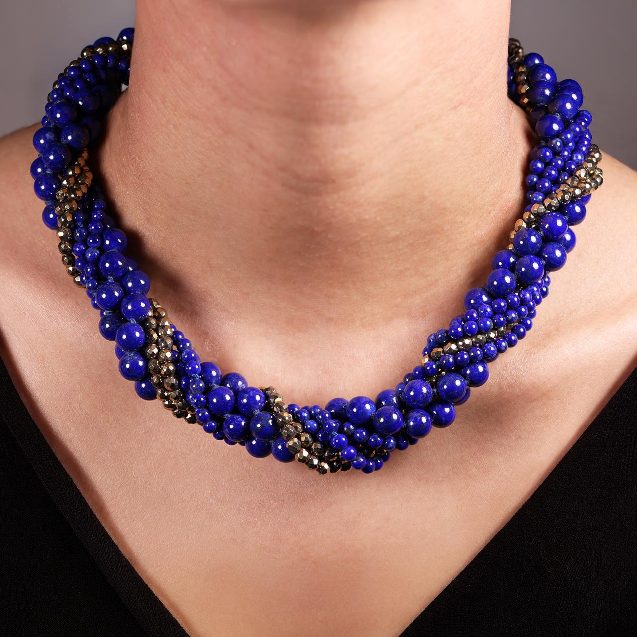 Blue lapis and gold plated hemitite beads bracelet ended with a gold plated silver magnetic clasp from The Carmela Cerrone Collection on the neck