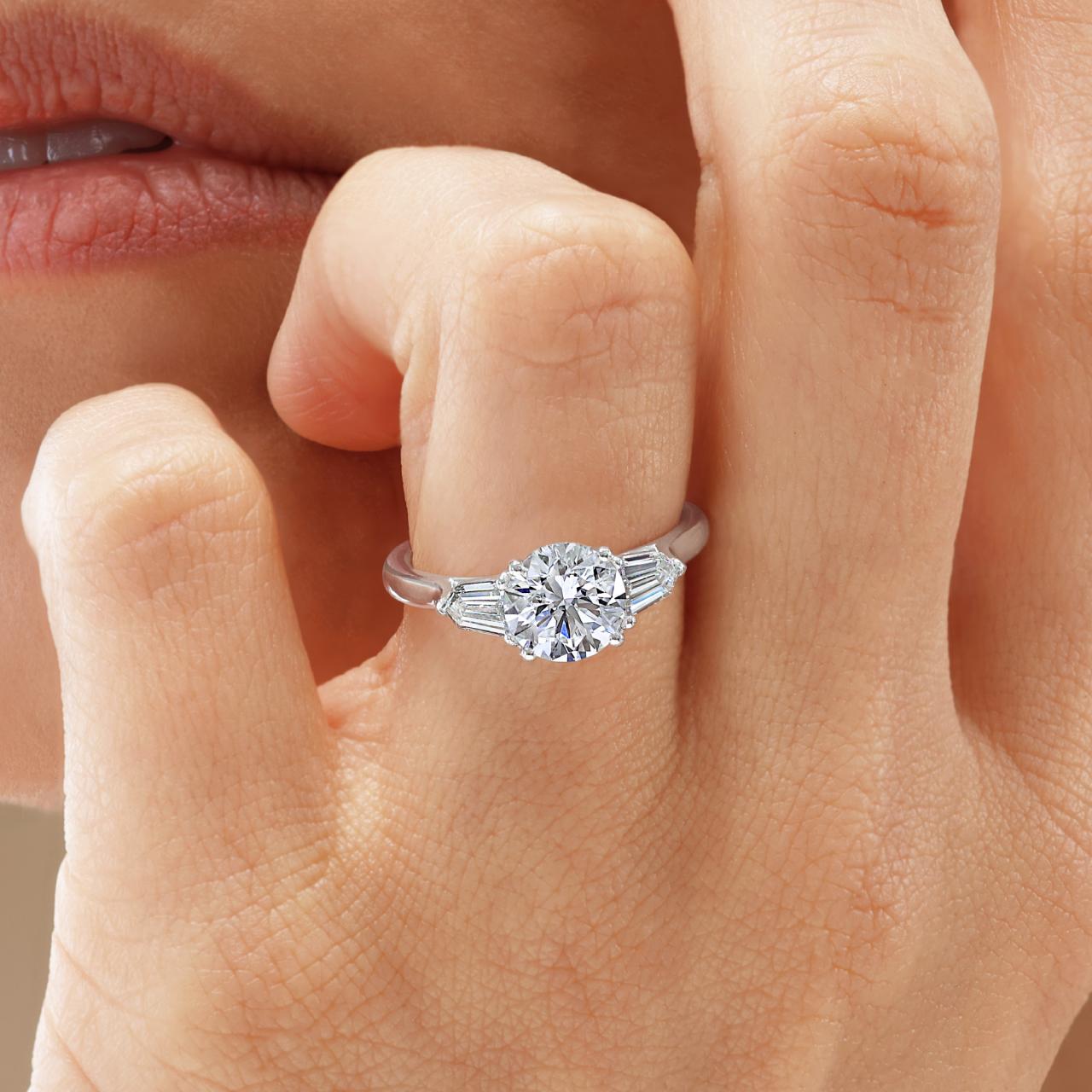 Platinum 1.50ct round brilliant cut diamond ring featuring 2=0.59ct bullet diamonds in a claw setting