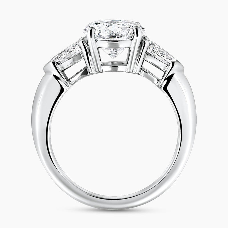 18ct white gold round brilliant cut diamond ring with pear shaped diamonds on the sides side profile view