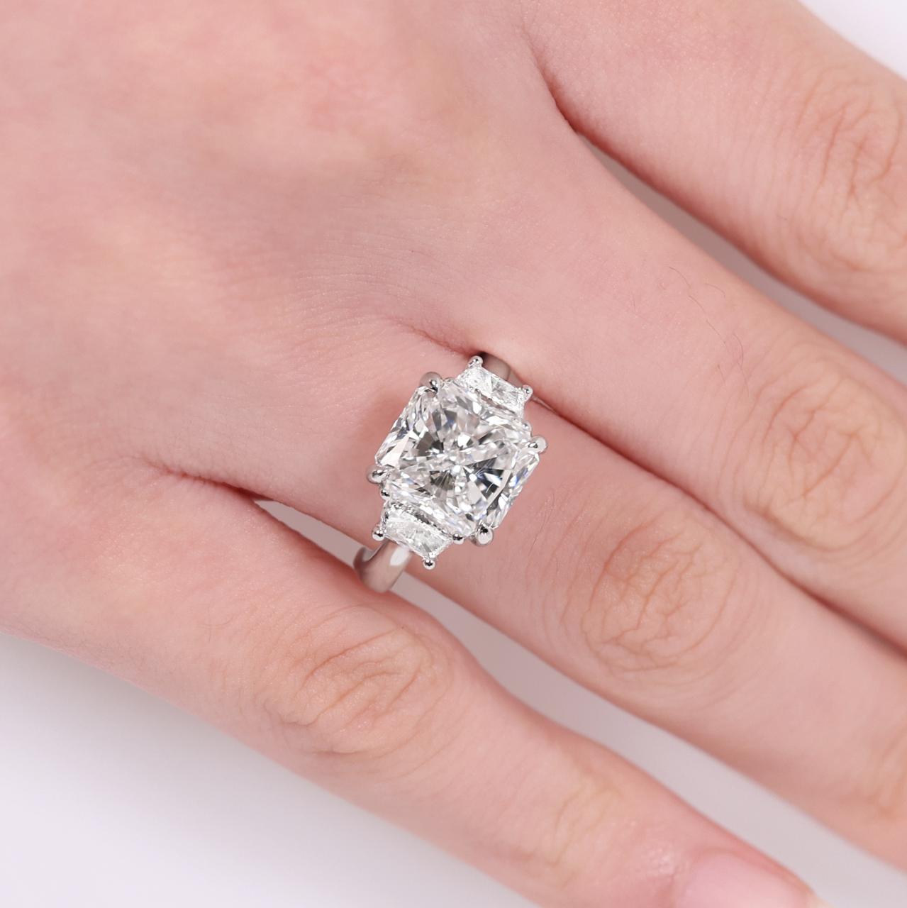 Platinum 5.03ct radiant diamond ring with 2=0.73ct trapezoid brilliant cut diamonds on the sides on finger