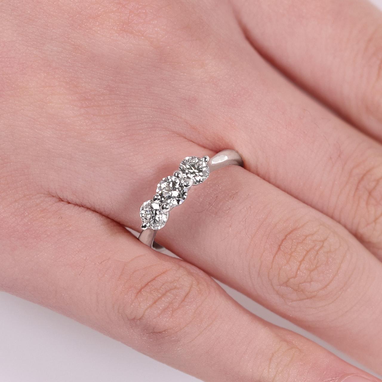 18ct white gold 0.80ct Round brilliant cut diamond ring with  2=0.62ct round brilliant cut diamonds on the side on finger