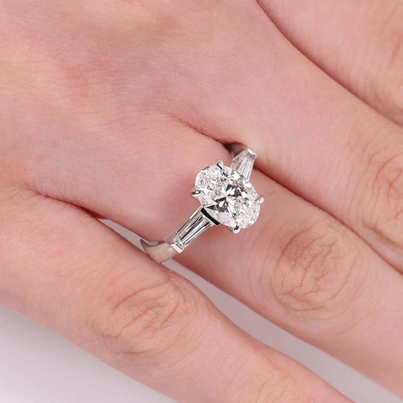 18ct white gold 1.80ct oval brilliant cut diamond ring features 2=0.46ct tapered baguette diamonds on finger